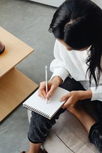 Kaboompics - Woman Writing in a Notebook Beside Coffee and Agave