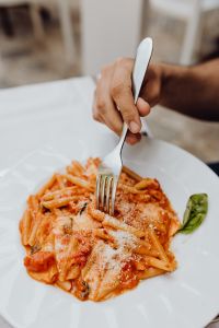 Kaboompics - Hand Holding Fork over Tomato Pasta with Parmesan and Basil