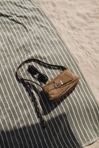 Kaboompics - Brown Leather Bag on a Striped Beach Towel
