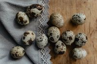 Kaboompics - Quail Eggs Scattered on Linen and Wood Background