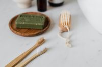 Kaboompics - Olive Soap and Wooden Nail Brushes on a Round Tray, Natural Hygiene Products for Spa Branding