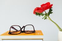 Kaboompics - Reading Glasses, Red Poppies and Books in a Bright Still Life