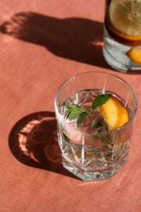 Kaboompics - Peach-Infused Water With Mint on Coral Background