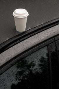 Kaboompics - Takeaway Coffee Cup on Rain-Covered Car