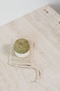 Kaboompics - Solid Green and White Soap Bars on a Crochet Washcloth, Neutral Background for Natural Skincare