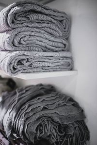Folded sweaters and fabrics stacked on shelves