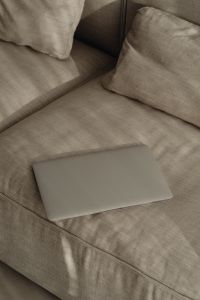 Kaboompics - Closed Laptop on Soft Neutral Sofa, Minimal Work From Home Background