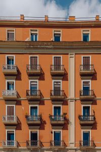 Kaboompics - Symmetrical Orange Apartment Facade With Small Balconies in Naples