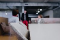 Kaboompics - Gray Upholstered Chair in Foreground with Blurred Visitors at a Design Exhibition