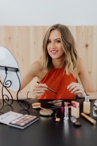 Kaboompics - Smiling Woman Portrait Beside a Vanity Mirror and Makeup Cosmetics