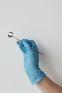Kaboompics - Dental Mirror Held by Gloved Hand With Copy Space