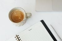 Kaboompics - Open Notes Notebook and Coffee beside a Laptop on White Marble