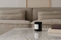 Kaboompics - Wide Beige Sofa and Black Candle on Marble Coffee Table