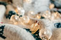 Kaboompics - Warm Fairy Lights and Silver Ornaments on a Soft Blanket