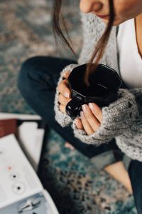 Kaboompics - Woman reading magazines on the floor while enjoying her cup of tea