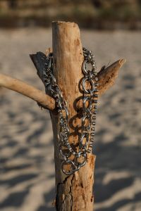 Kaboompics - Silver Necklaces on Driftwood with Soft Beach Background
