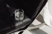 Kaboompics - Overhead Glass of Water on Black Leather Chair in Sunlight
