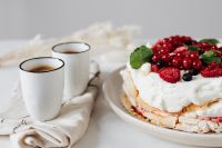 Kaboompics - Meringue Cake and Fresh Berries with Two Espresso Cups in Soft Window Light