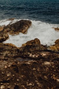 Kaboompics - White Wave Crashing Over Sunlit Coastal Rocks