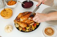 Kaboompics - Overhead Hands Carving Turkey with Cranberry Sauce and Pie