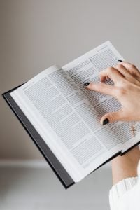 Kaboompics - Finger Pointing to Scripture in an Open Bible with Gold Bracelet