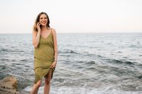 Kaboompics - Smiling Woman on a Phone Call at the Seaside, Green Dress and Relaxed Summer Travel