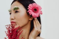 Kaboompics - Asian Woman Profile with Pink Gerbera Behind Ear and Red Botanical Accents