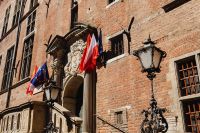 Kaboompics - Gdańsk Poland Historic Townhouse Facade with National Flags and Ornate Street Lanterns
