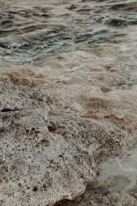 Kaboompics - Foamy Sea Water over Pitted Limestone Coastal Texture
