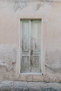 Kaboompics - Peeling White Wooden Door in a Weathered Plaster Wall