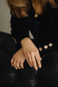 Kaboompics - Seated Woman Showing Gold Rings and Pendant Necklace