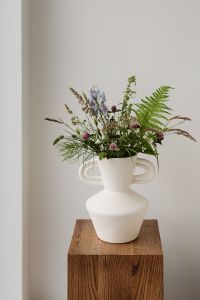 Kaboompics - Sculptural White Vase with Wildflower Arrangement on Wooden Pedestal