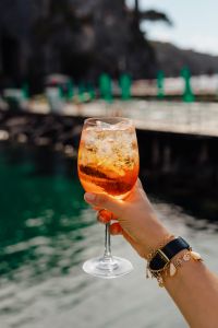 Kaboompics - Cropped Aperol Spritz beside Pier Rail and Dark Coast