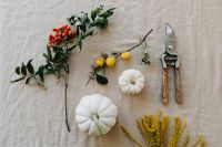 Kaboompics - Autumn Flat Lay with White Pumpkins, Goldenrod, Red Berries, Citrus and Pruning Shears on Beige Linen