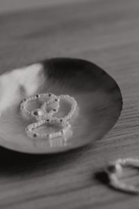 Kaboompics - Monochrome Pearl Bead Rings in a Seashell on a Wooden Table, Vertical Still Life