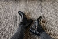 Kaboompics - Black Leather Ankle Boots with Block Heels and Black Jeans on Textured Rug