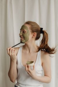 Kaboompics - Smiling Woman Applying a Clay Face Mask with a Brush