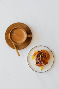 Kaboompics - Coffee Cup, Cinnamon Roll and Open Book, Overhead View
