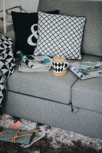 Kaboompics - Cozy Living Room Sofa with Coffee Cup, Magazines and Geometric Throw
