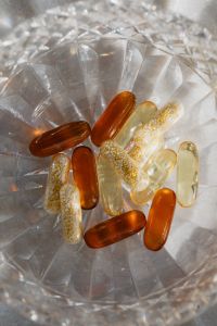 Kaboompics - Close-Up Amber and Herbal Capsules in Crystal Bowl