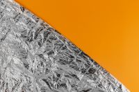 Kaboompics - Silver Foil Texture & Orange Background