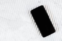 Kaboompics - Single Black Smartphone with Blank Screen and Marble Copy Space, Vertical Flat Lay