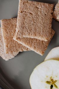 Kaboompics - Overhead Whole-Grain Crispbread with Fresh Apple Slices on a Neutral Gray Surface