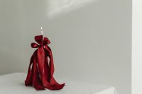 Kaboompics - Red Satin Bow and Candle Styled in a Minimal White Room