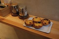 Kaboompics - Portuguese Pastel de Nata Tarts on a Wooden Cafe Counter with Spice Jars