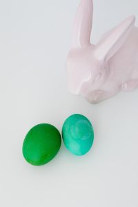 Kaboompics - White Easter Bunny Figurine with Two Green Eggs