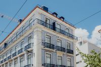 Kaboompics - Blue Azulejo Apartment Facade with Wraparound Balconies and Tram Cables