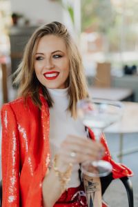 Kaboompics - Smiling Woman in Red Blazer Raising Champagne Glass