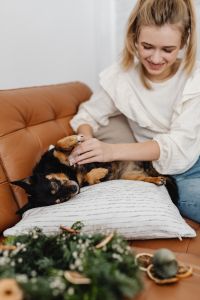 Kaboompics - Woman Cuddling Small Dog on Brown Sofa