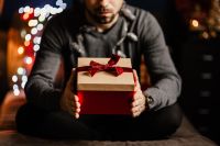 Kaboompics - Man Surrounded by Wrapped Gifts in Warm Christmas Setting